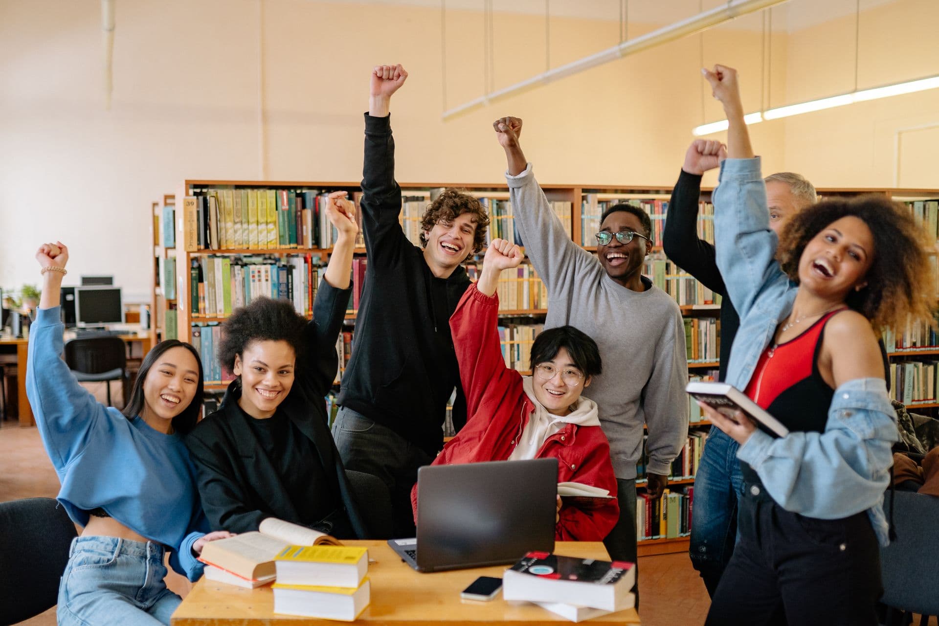 Estudantes celebrando conquista acadêmica em biblioteca